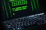 Close-up of a laptop screen displaying green code text. Perfect for cybersecurity themes.