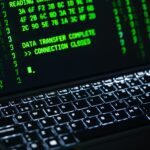Close-up of a laptop screen displaying green code text. Perfect for cybersecurity themes.